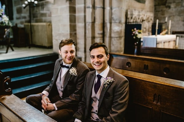 Groom and best man sitting in church before ceremony