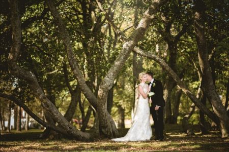 Bride and groom standing by trees - Picture by Natalie Johansson Fotograf