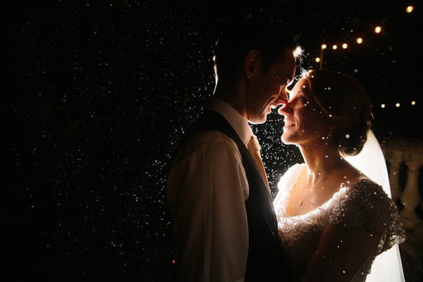 Bride and groom in rain at night - Picture by Stephen McGowan Wedding Photography