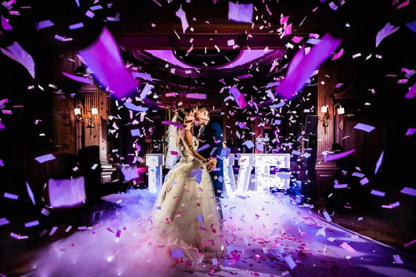 Bride and groom on dance floor with paper confetti falling around them - Picture by Andy Griffiths Photography