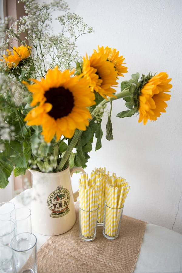Sunflowers and straws on table