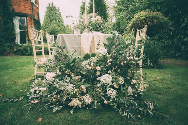 Large floral display at end of wedding table