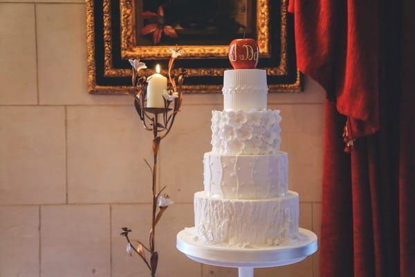 Tiered white wedding cake with apple topper