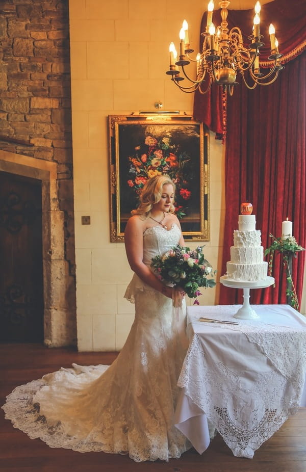 Bride standing by wedding cake