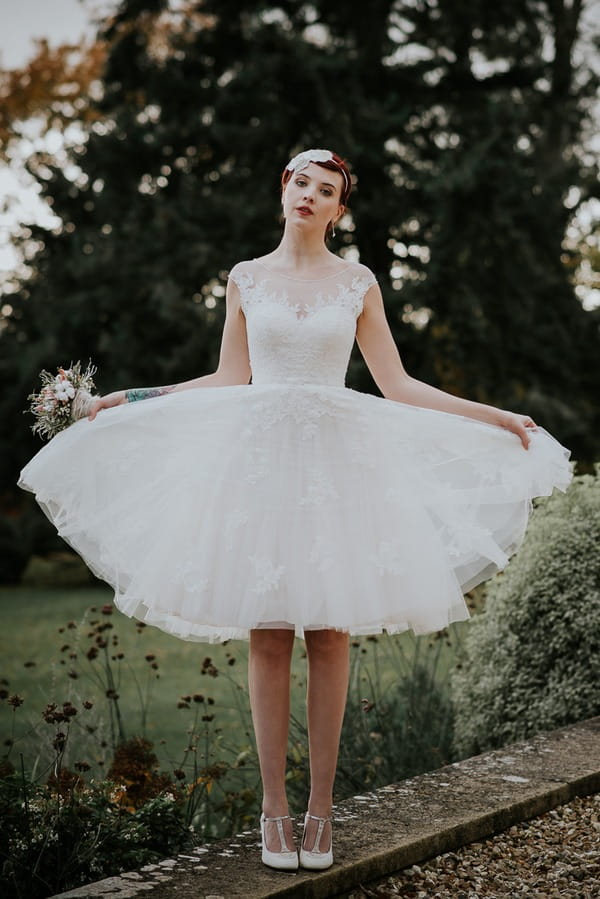 Bride holding out skirt on wedding dress