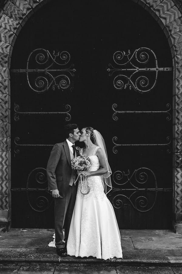 Bride and groom kissing outside church