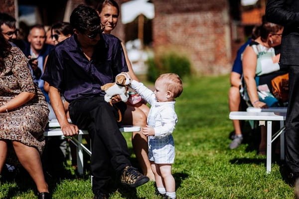 Young child with toy dog at wedding