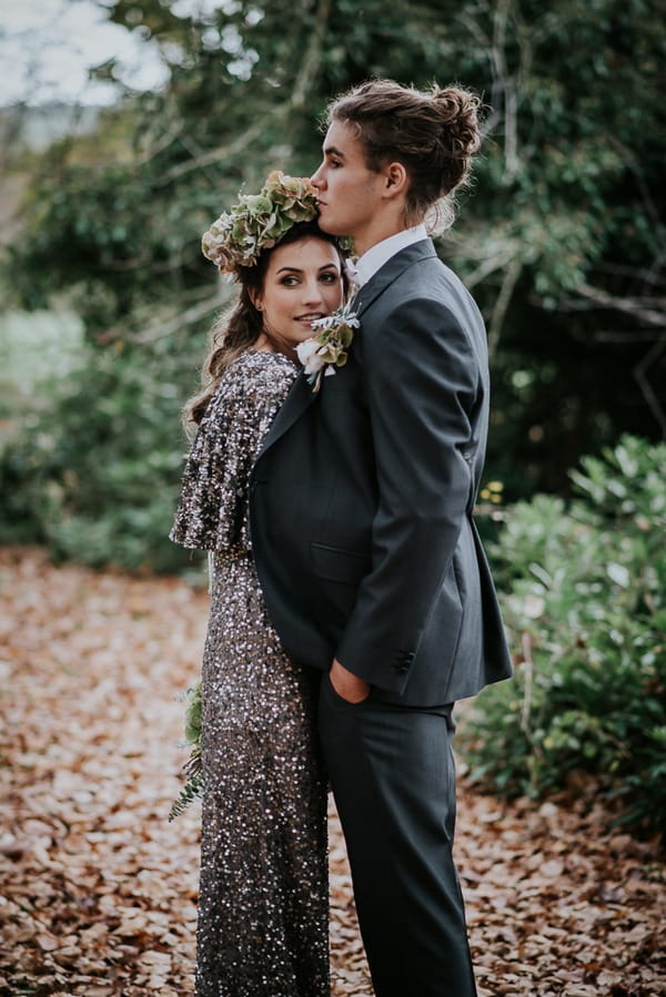 Bride hugging groom under his jacket