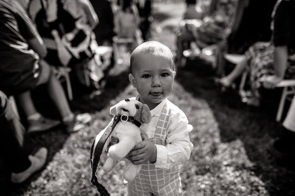 Young child carrying toy dog down aisle