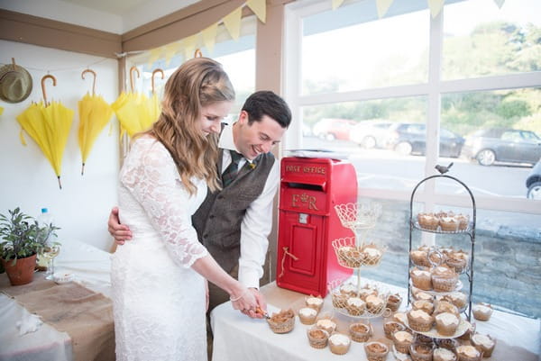 Bride and groom cutting cupcake