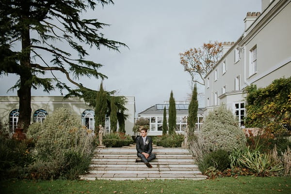 Groom sitting on steps at Deer Park