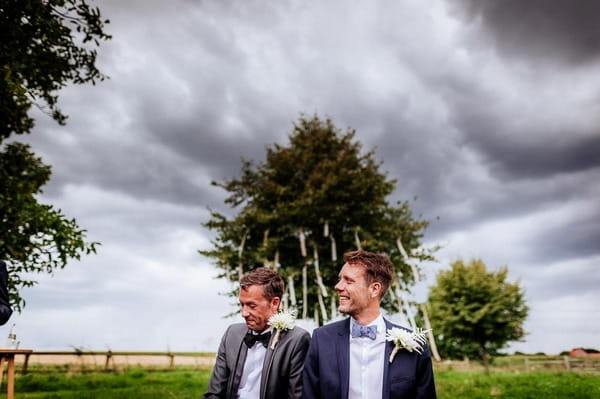 Storm clouds gathering over grooms at wedding