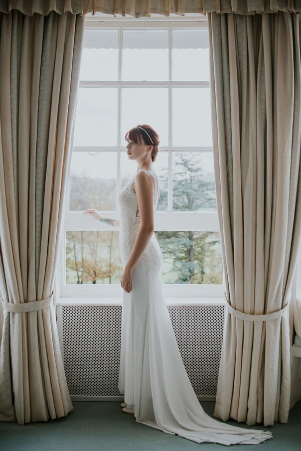 Bride standing by window