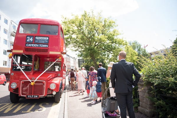 Wedding guests boarding red bus