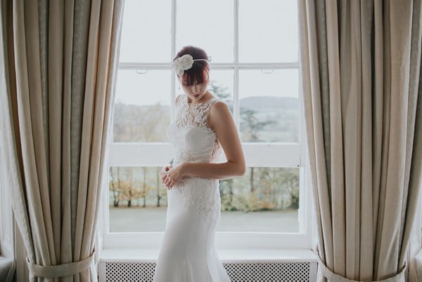 Bride looking down in front of window