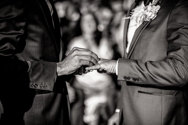 Grooms exchanging wedding rings