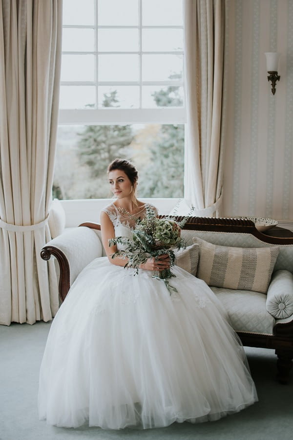 Bride holding bouquet sitting down