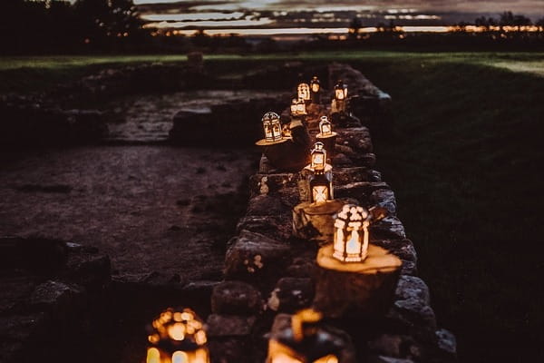 Lit lanterns in a row on wall