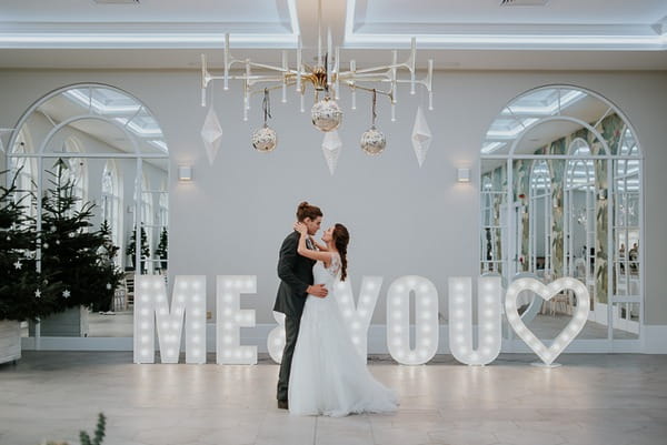 Bride and groom in front of large letters