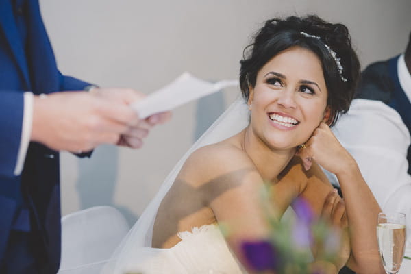 Bride listening to groom speech and smiling