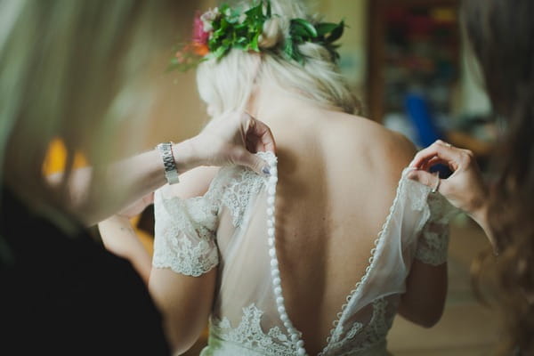 Doing up back of bride's dress