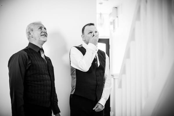 Emotional man with hand over mouth as he sees bride walking down stairs - Picture by Venetia Norrington Photography