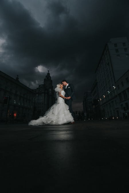 Bride and groom in middle of road with dark clouds overhead - Picture by Squashed Apple