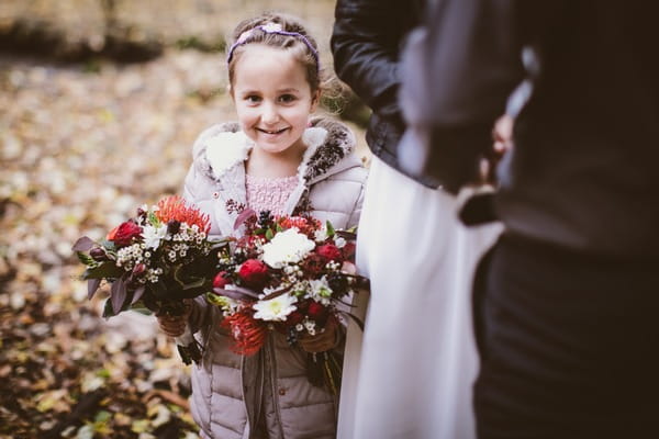 Flower girl smiling holding bouquet