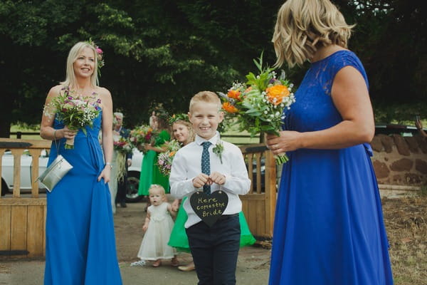 Boy carrying Here Comes the Bride sign