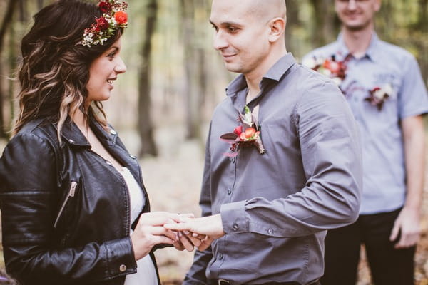 Bride putting ring on groom's finger