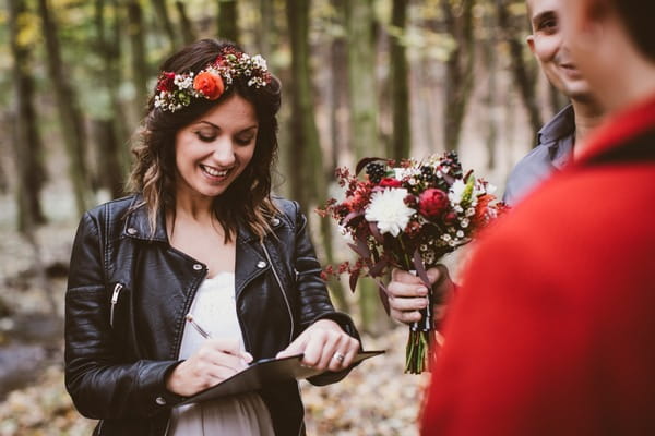 Bride signing marriage document on clipboard