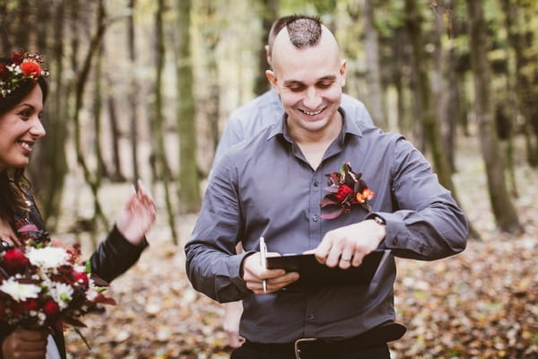 Groom signing marriage document on clipboard