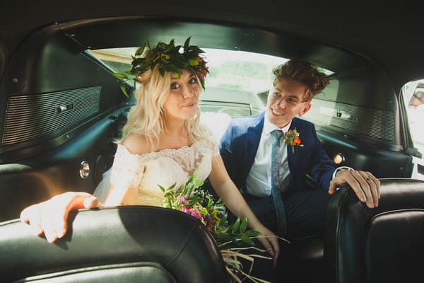 Bride and groom in back of wedding car