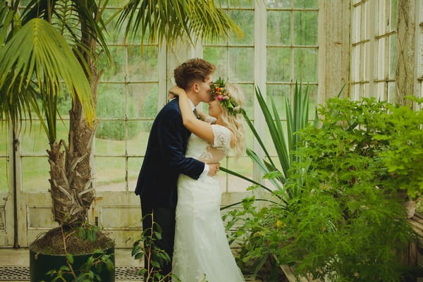 Groom kissing bride on head