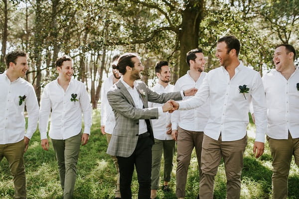 Groom shaking hands with groomsman