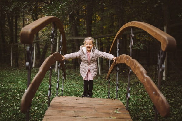 Flower girl standing on small bridge