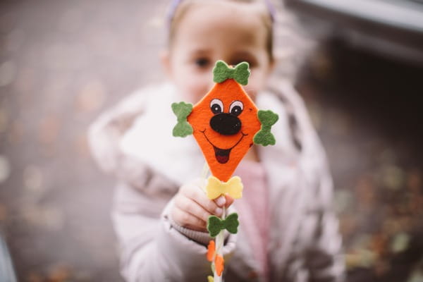 Flower girl holding out face on stick