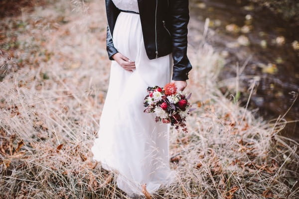 Pregnant bride touching her bump