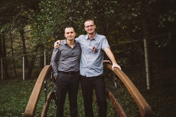 Groom and best man on small bridge