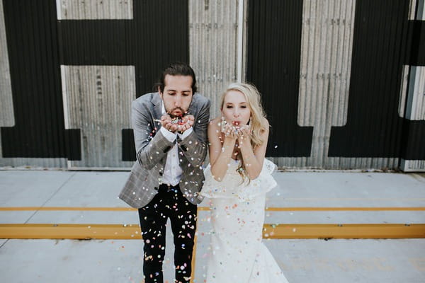 Bride and groom blowing confetti from hands