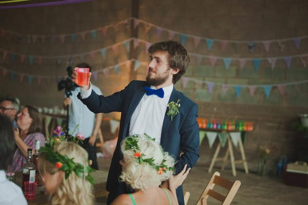 Man raising drink for wedding toast