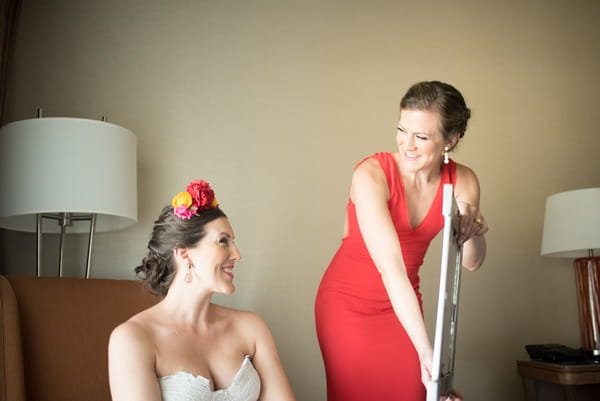 Bridesmaid holding mirror so bride can see herself
