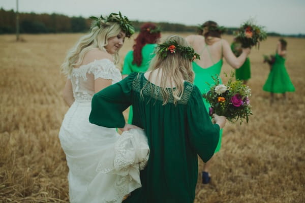 Bride and bridesmaids walking across field