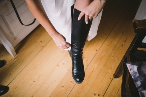 Bride putting leather boots on