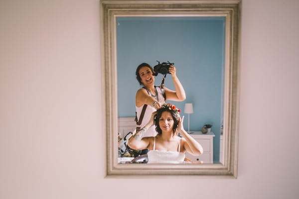 Photographer taking picture of herself and bride in mirror