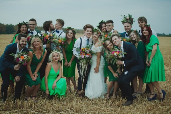 Bridal party posing for picture in a field