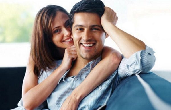 Happy couple sitting on sofa