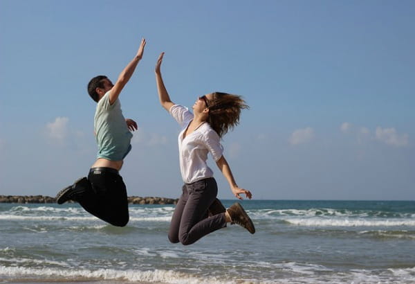Couple jumping and doing high five in the air