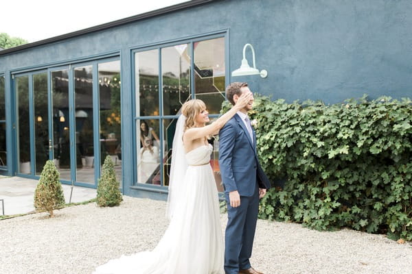 Bride covering groom's eyes for wedding first look