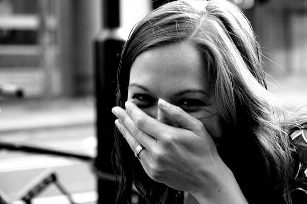 Woman laughing with hand over mouth